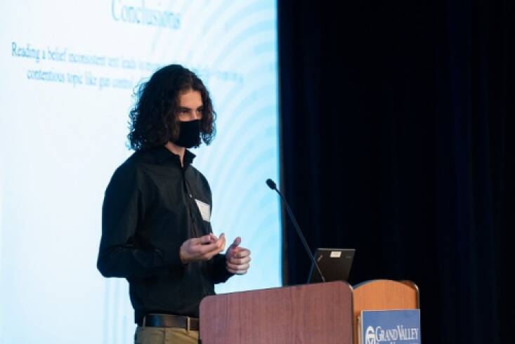 Liam Hart (Student Summer Scholar) presenting his research behind a podium